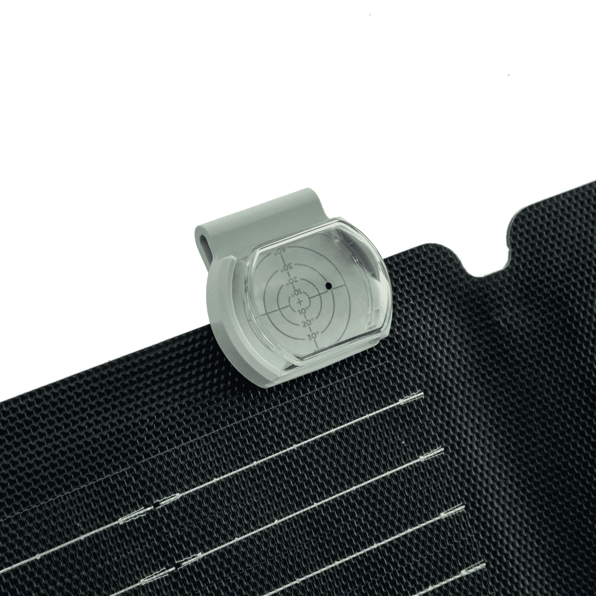 Ein solar Neigungswinkelmesser mit transparenter Abdeckung und Skala für Winkelgrade, angebracht auf einer strukturierten, schwarzen Oberfläche mit feinen Linien.